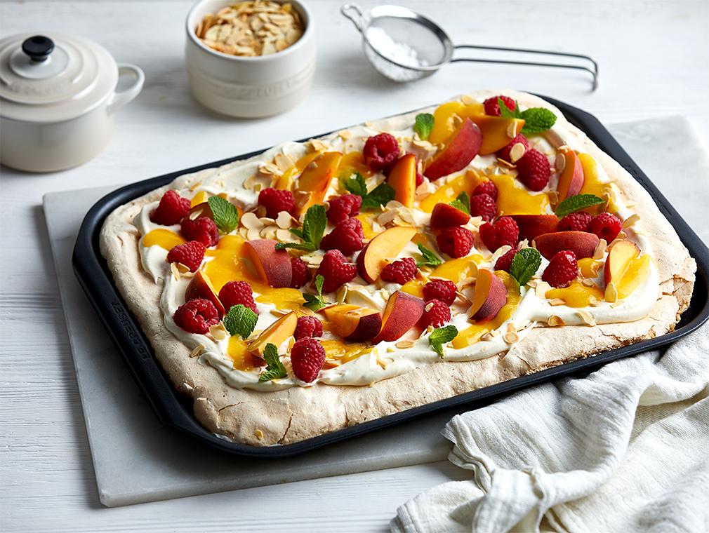 Tort Pavlova z brzoskwiniami, malinami i migdałami